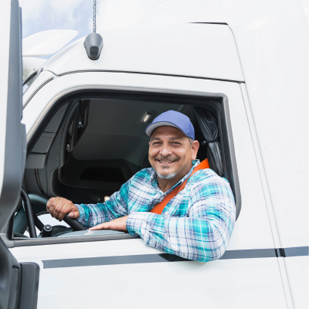 Trucker with a blue hat putting an elbow and leaning outside of the window